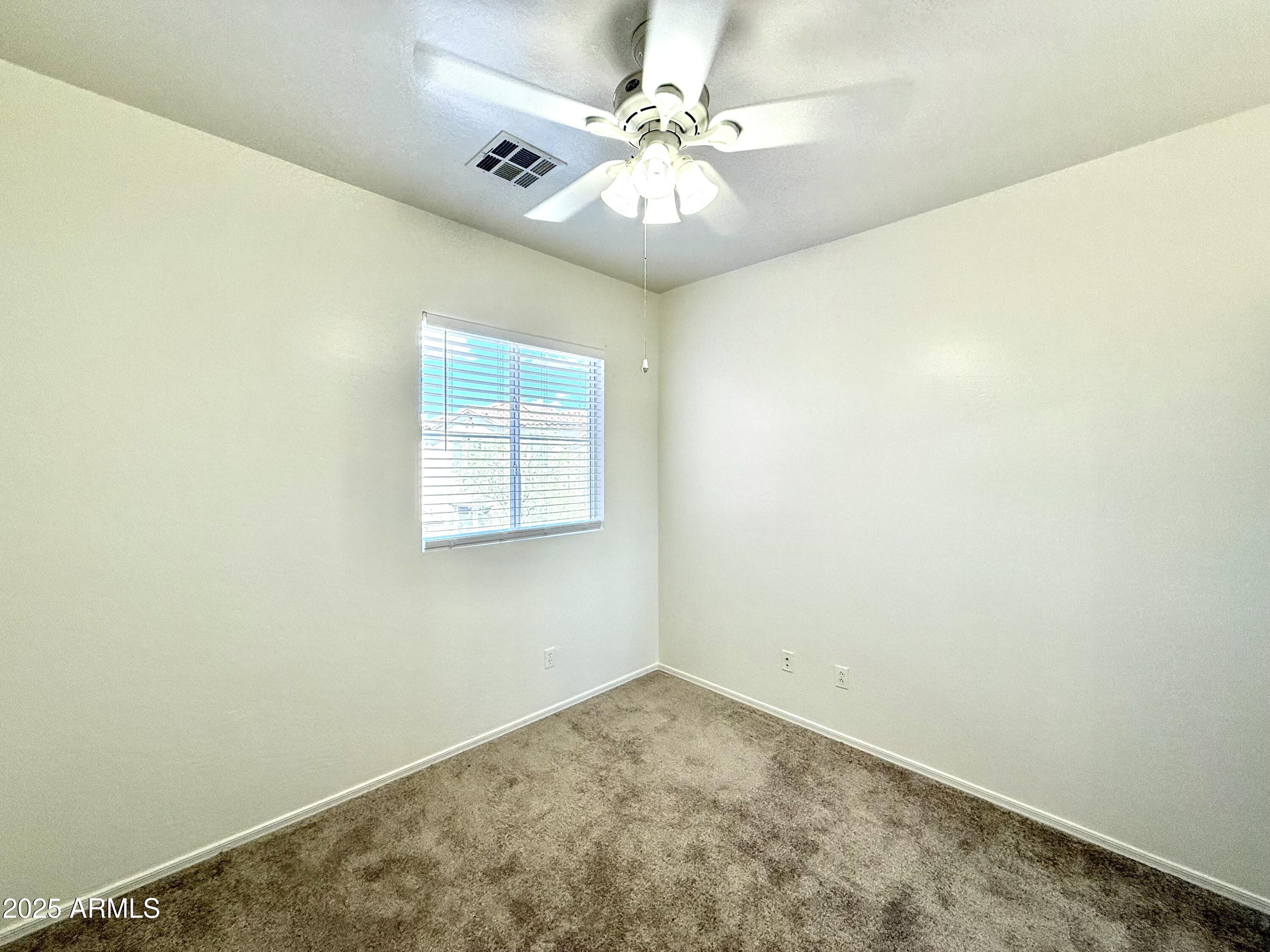 34924 North 30th Avenue Phoenix, AZ 85086 - Photo 15 of 20 an empty room with a chandelier fan and windows