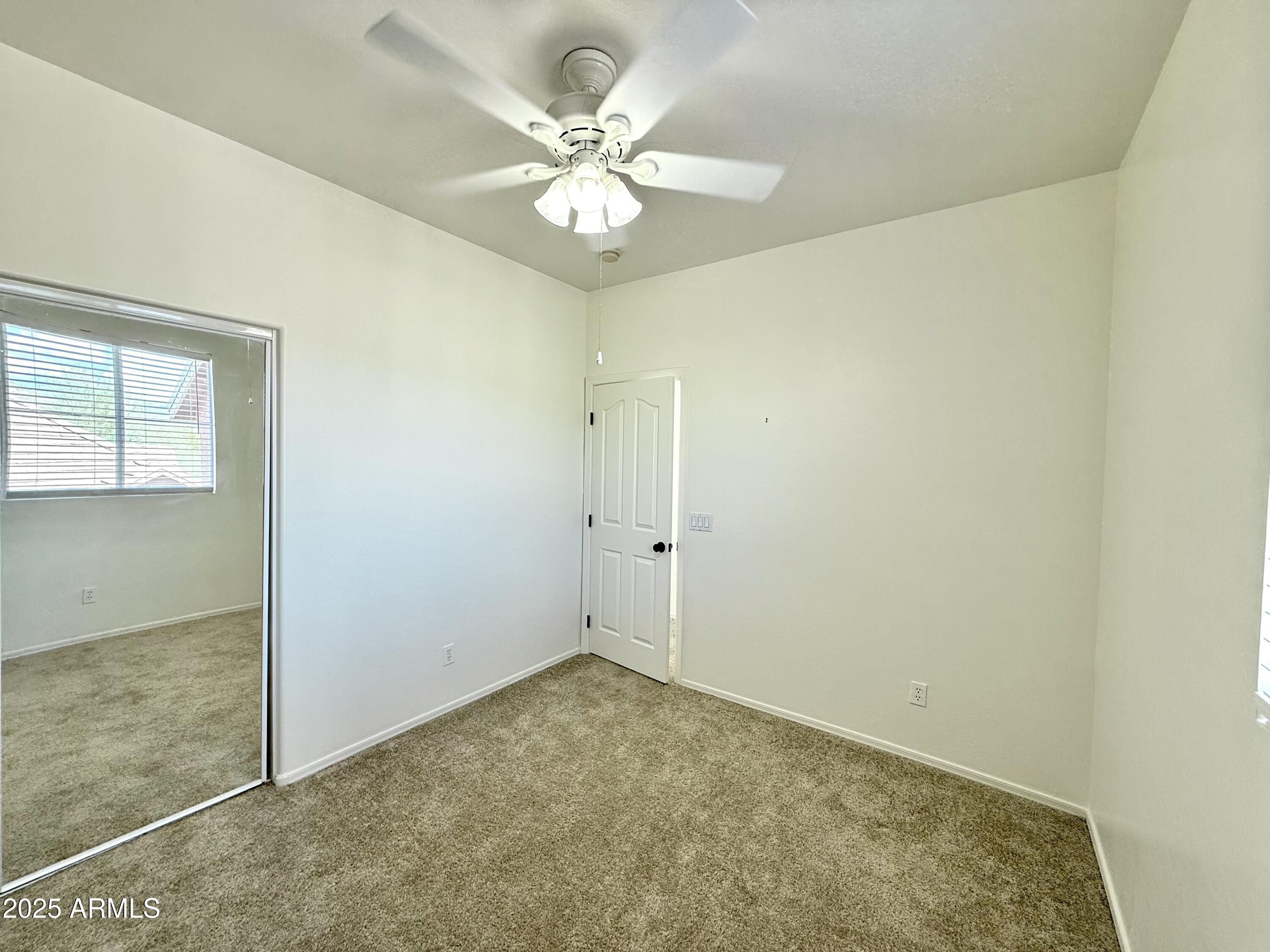 34924 North 30th Avenue Phoenix, AZ 85086 - Photo 16 of 20 an empty room with a chandelier fan and windows