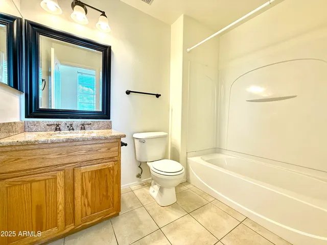 a bathroom with a granite countertop toilet sink and mirror