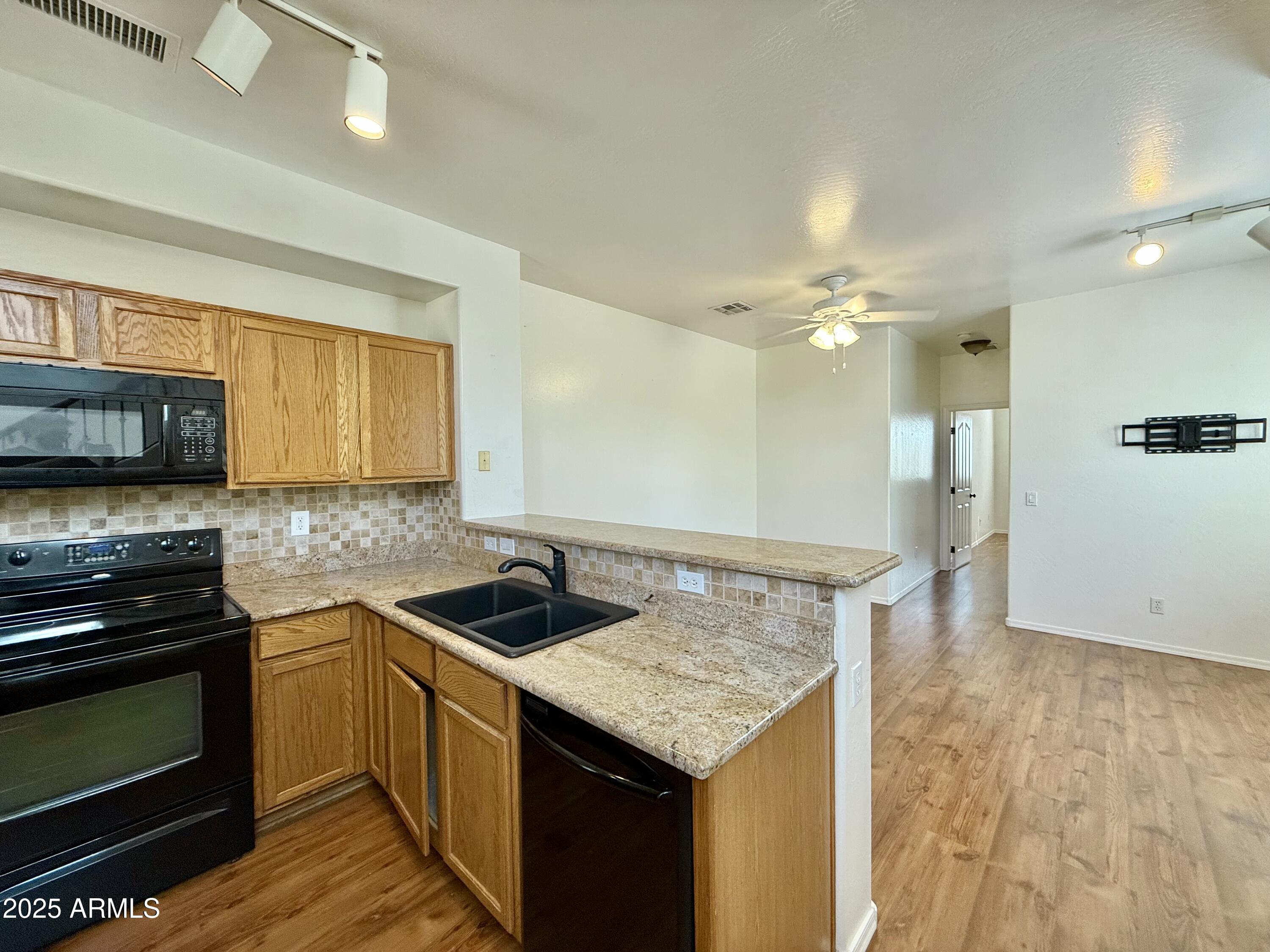 34924 North 30th Avenue Phoenix, AZ 85086 - Photo 5 of 20 a kitchen that has a sink a microwave oven a stove and white cabinets with wooden floor