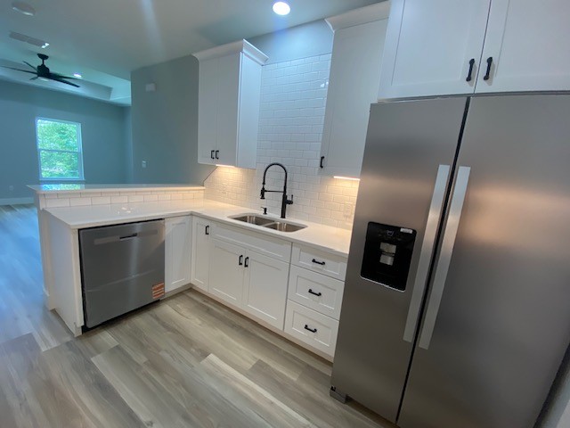 116 Field Street Luling, TX 78648 - Photo 8 of 33 A pristine kitchen features modern white cabinetry, stainless steel appliances, and sleek flooring.