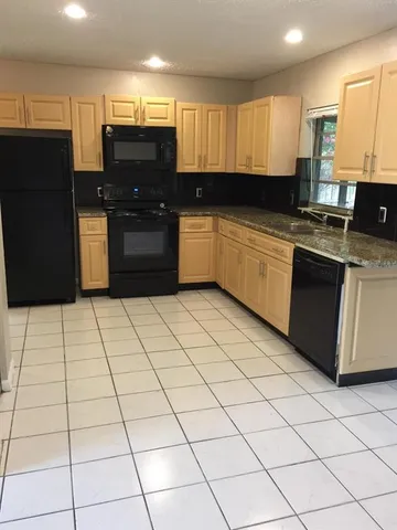 a kitchen with stainless steel appliances a refrigerator sink and cabinets