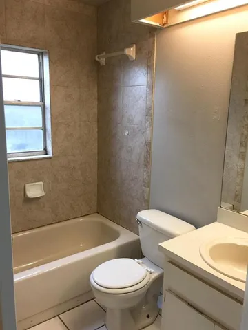 a white toilet sitting next to a bath tub and a shower