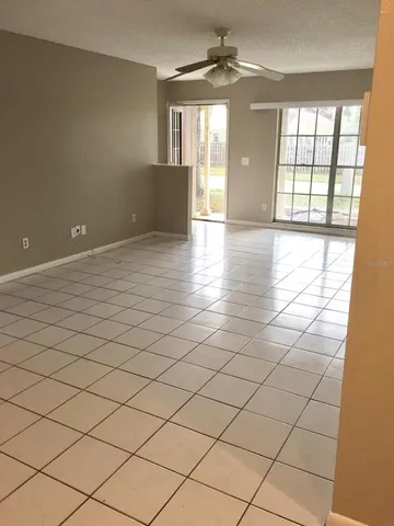 an empty room with chandelier and windows
