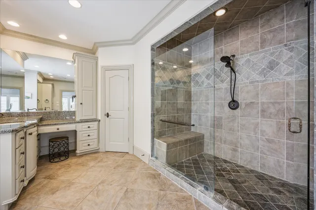 a bathroom with a granite countertop sink a mirror and a shower