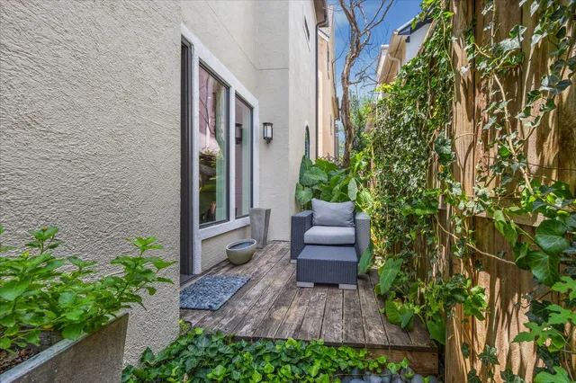 a view of a couches in the patio with potted plants