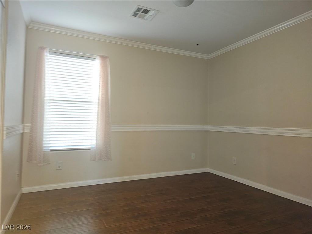 11081 Village Ridge Lane Las Vegas, NV 89135 - Photo 16 of 18 Empty room with crown molding and dark wood-style flooring