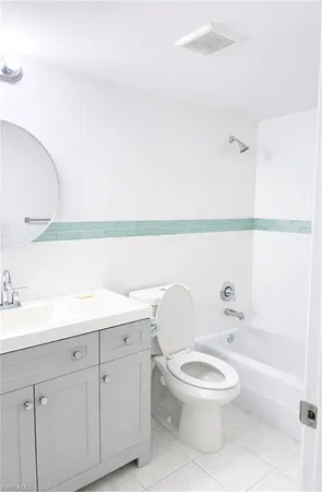 a bathroom with a granite countertop toilet sink and mirror