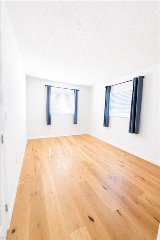 3325 Airport Road North, Unit F1 Naples, FL 34105 - Photo 6 of 7 Empty room featuring a textured ceiling and light wood finished floors