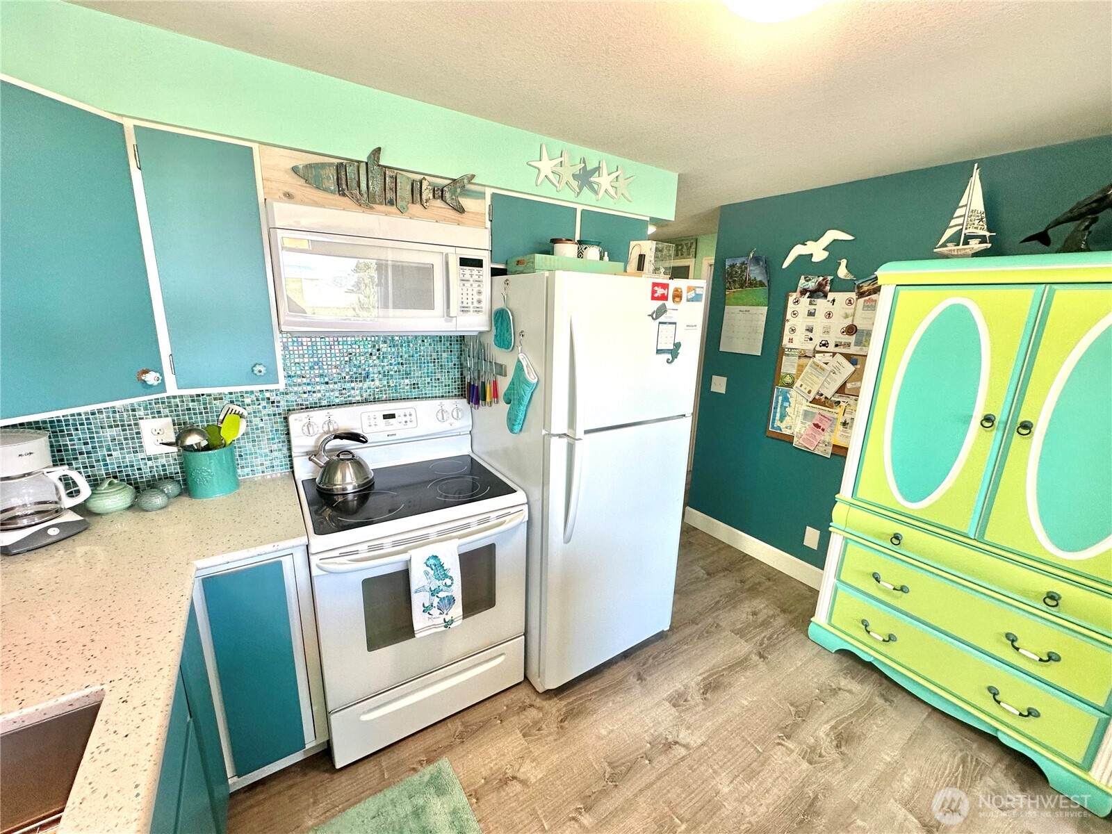 15217 Pacific Way Long Beach, WA 98631 - Photo 11 of 40 a kitchen with granite countertop a refrigerator a stove a washer and dryer