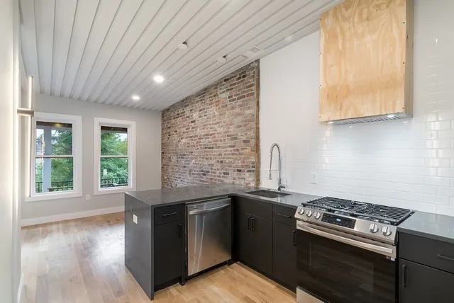 a kitchen with granite countertop a stove and a sink