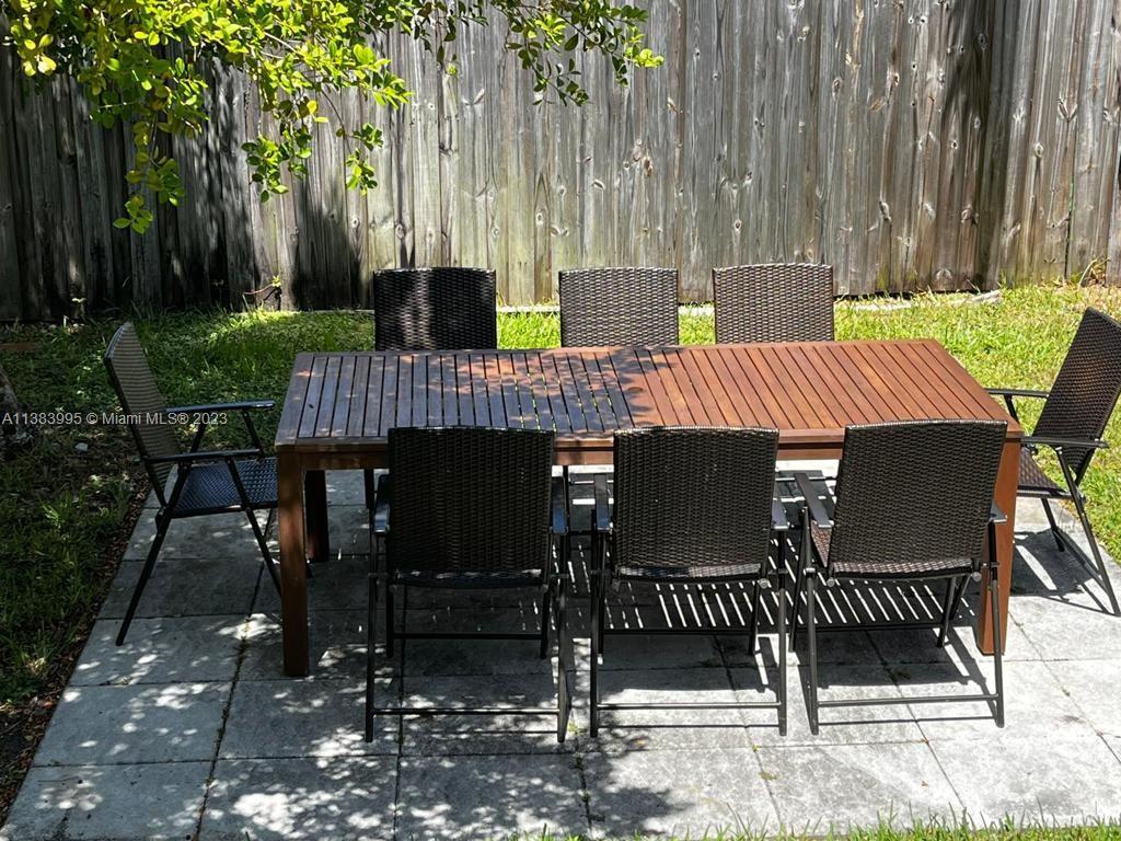 1411 Normandy Drive Miami Beach, FL 33141 - Photo 23 of 23 a view of a patio with table and chairs with wooden fence