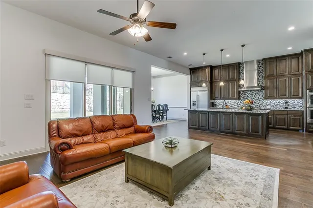 a living room with furniture kitchen view and a large window