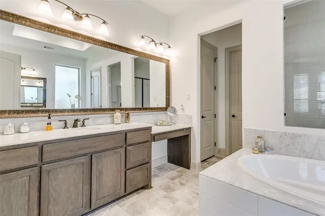 a bathroom with a tub sink and mirror
