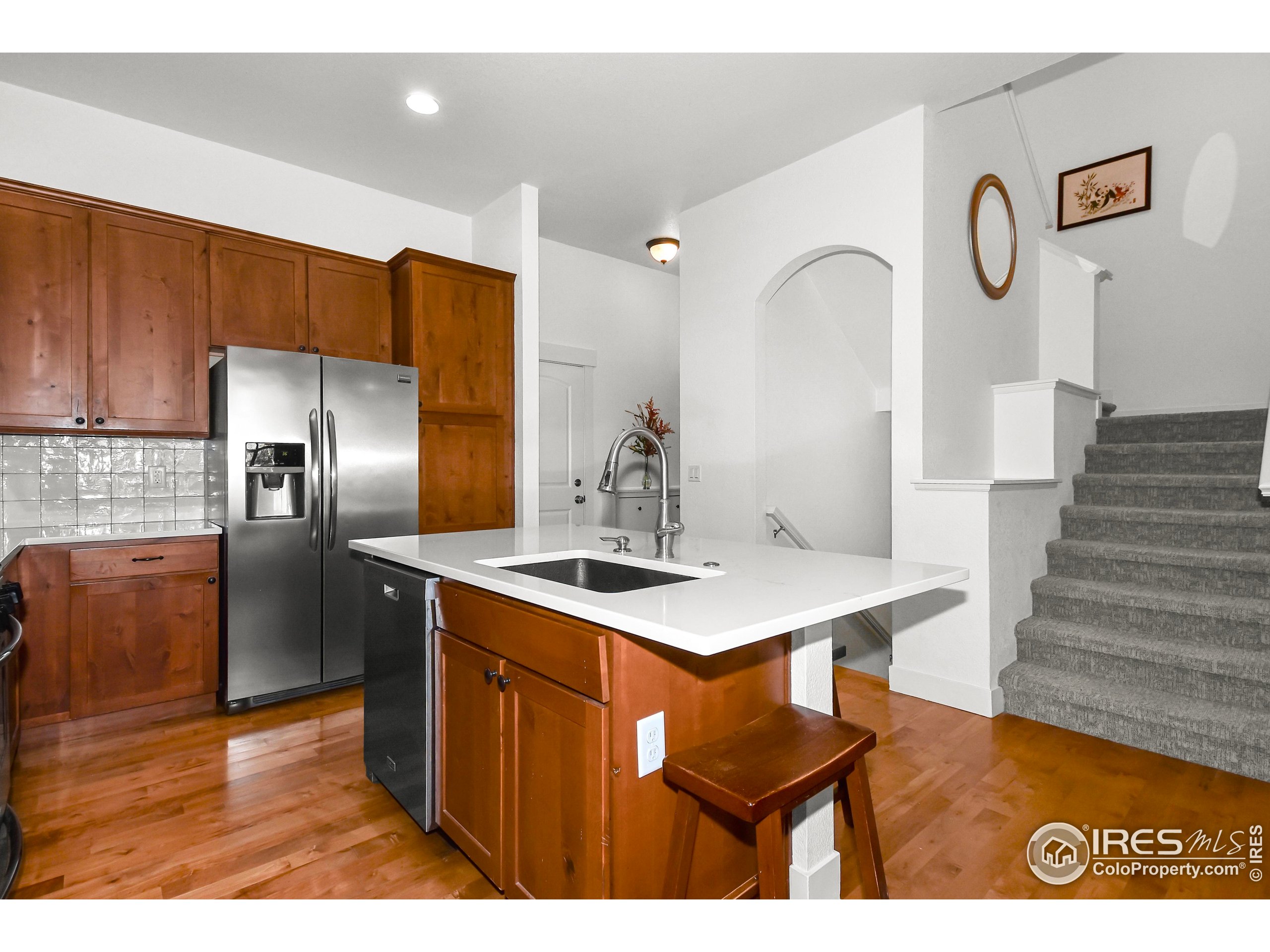 2172 Cape Hatteras Drive, Unit 2 Windsor, CO 80550 - Photo 15 of 46 a kitchen with cabinets a counter and stainless steel appliances