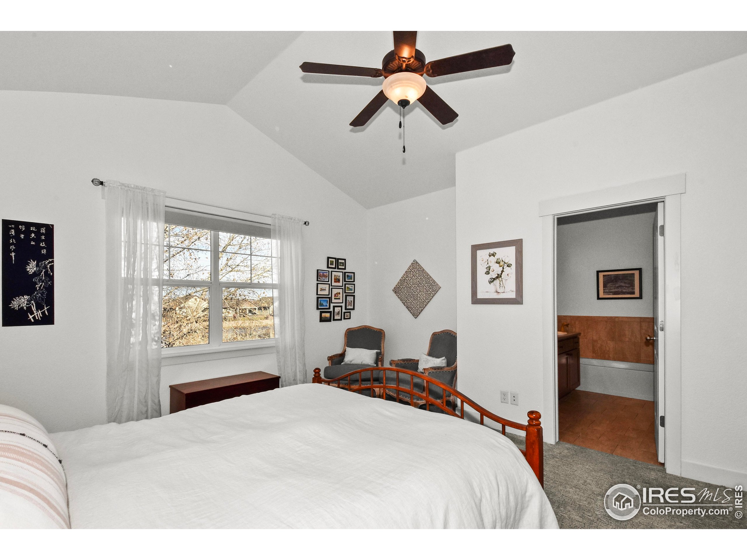 2172 Cape Hatteras Drive, Unit 2 Windsor, CO 80550 - Photo 22 of 46 a bedroom with a bed and a chandelier