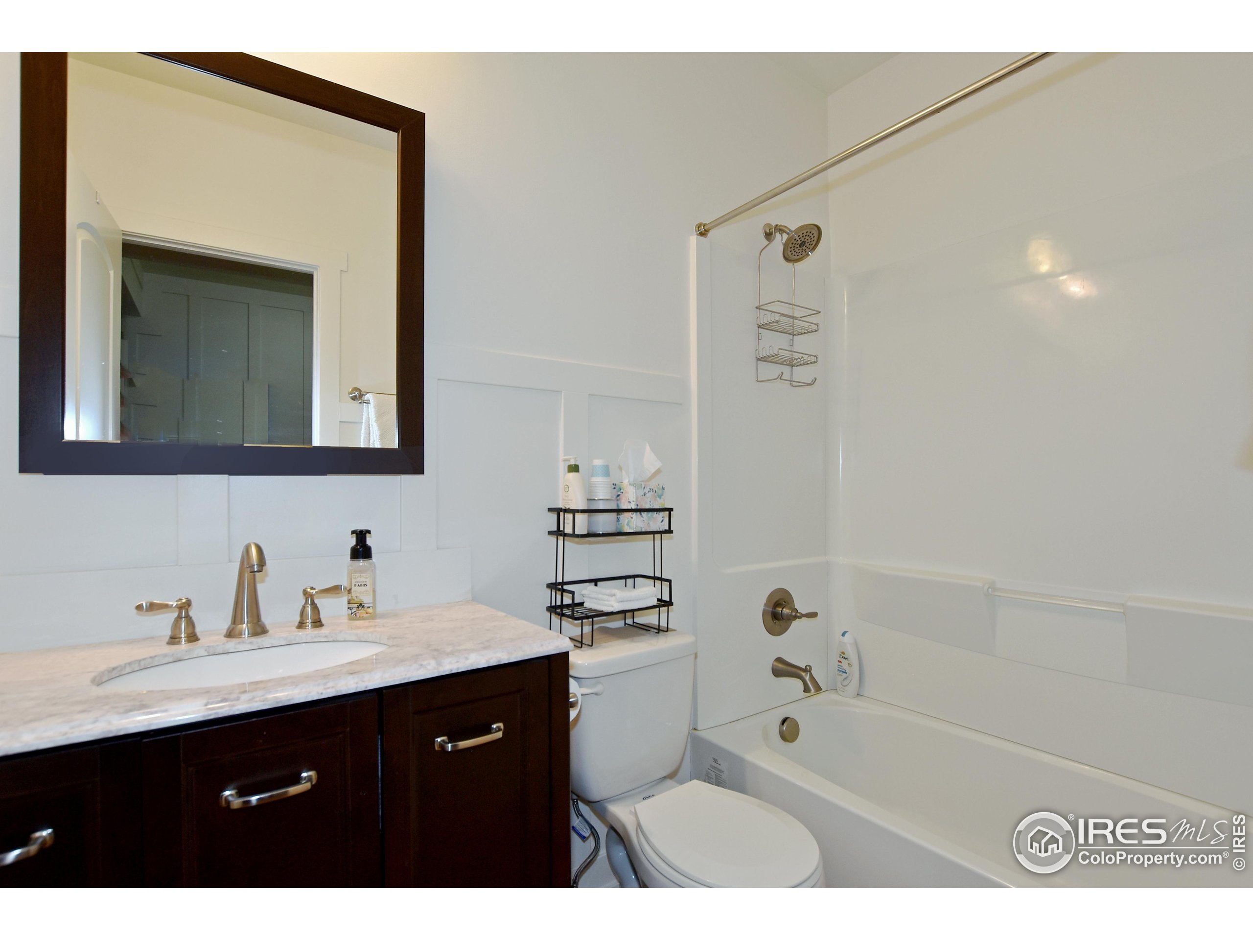 2172 Cape Hatteras Drive, Unit 2 Windsor, CO 80550 - Photo 36 of 46 a bathroom with a tub a sink and mirror