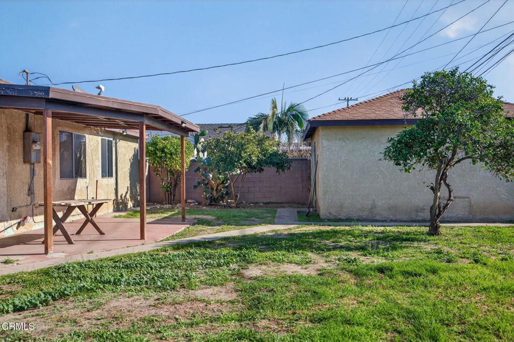 236 East Poplar Street Oxnard, CA 93033 - Photo 18 of 20 a view of a backyard with a table and chairs and potted plants