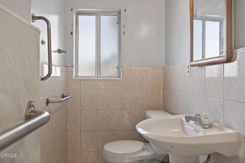 236 East Poplar Street Oxnard, CA 93033 - Photo 8 of 20 a bathroom with a sink a toilet and mirror