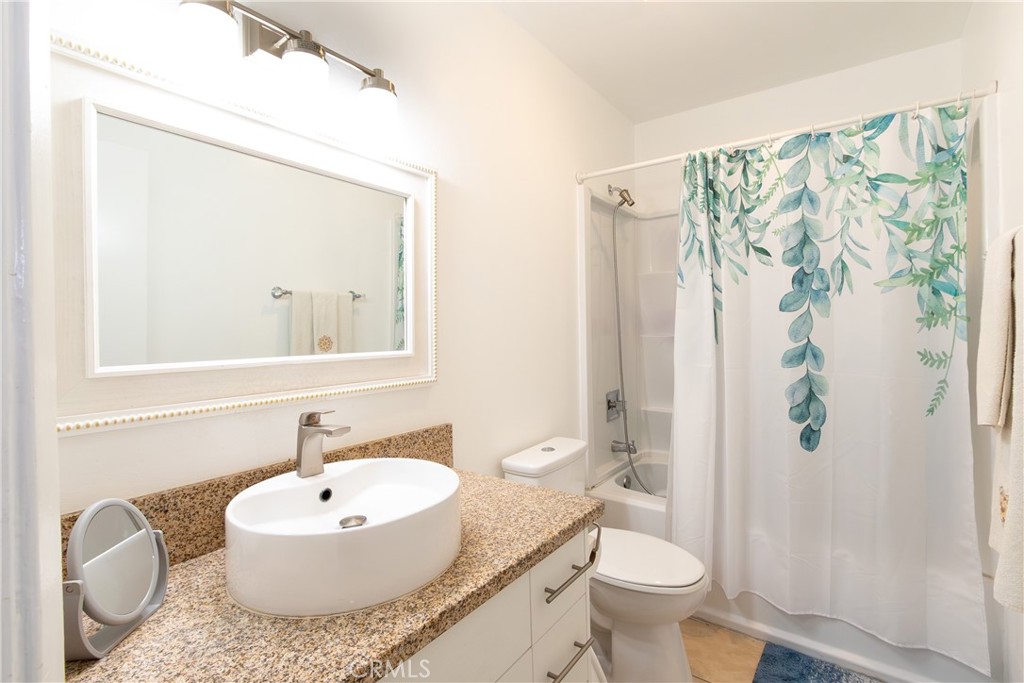 9551 Vía Ricardo Burbank, CA 91504 - Photo 14 of 29 a bathroom with a granite countertop sink toilet a mirror and shower