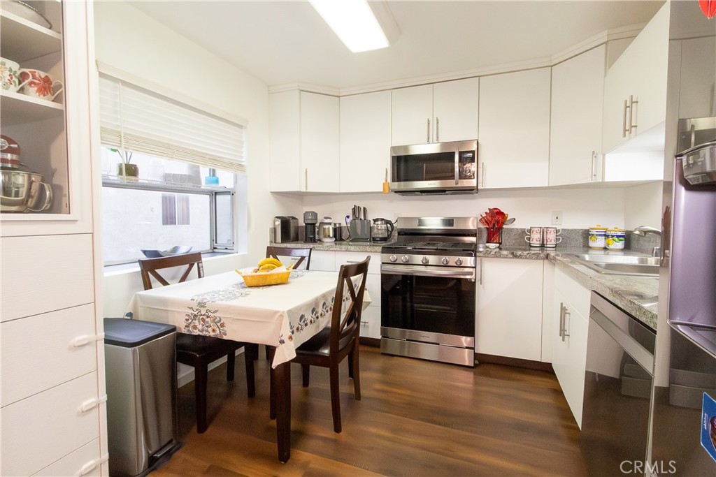 9551 Vía Ricardo Burbank, CA 91504 - Photo 6 of 29 a kitchen with stainless steel appliances granite countertop a stove a sink a microwave a refrigerator and white cabinets with wooden floor