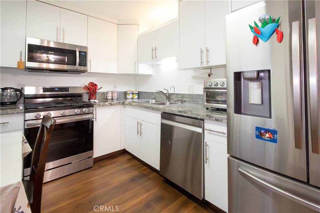 9551 Vía Ricardo Burbank, CA 91504 - Photo 7 of 29 a kitchen with stainless steel appliances a stove a microwave sink and cabinets