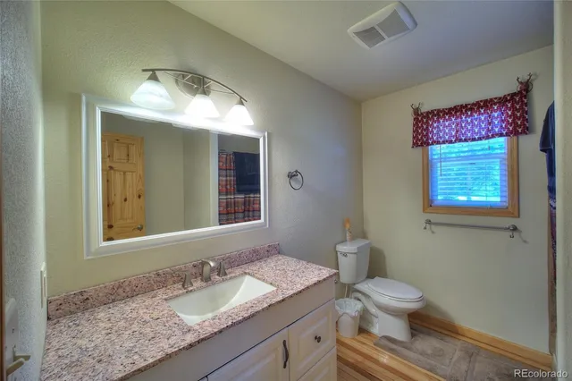 a bathroom with a granite countertop sink and a mirror