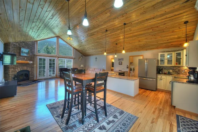a dining room with furniture a fireplace and wooden floor