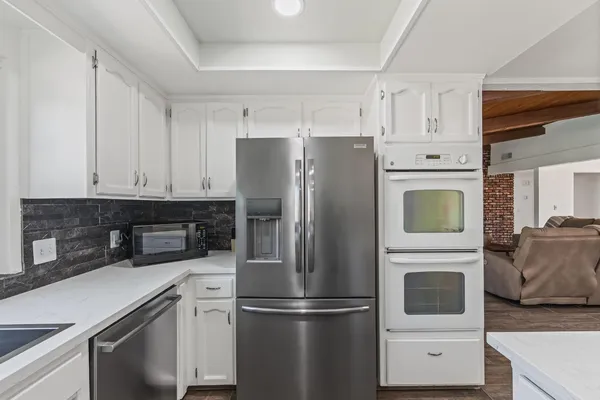 a kitchen with stainless steel appliances and white cabinets