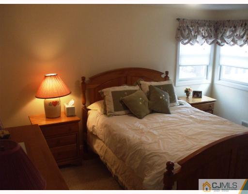 81 Westminster Road Colonia, NJ 07067 - Photo 6 of 9 a bedroom with a bed and a lamp