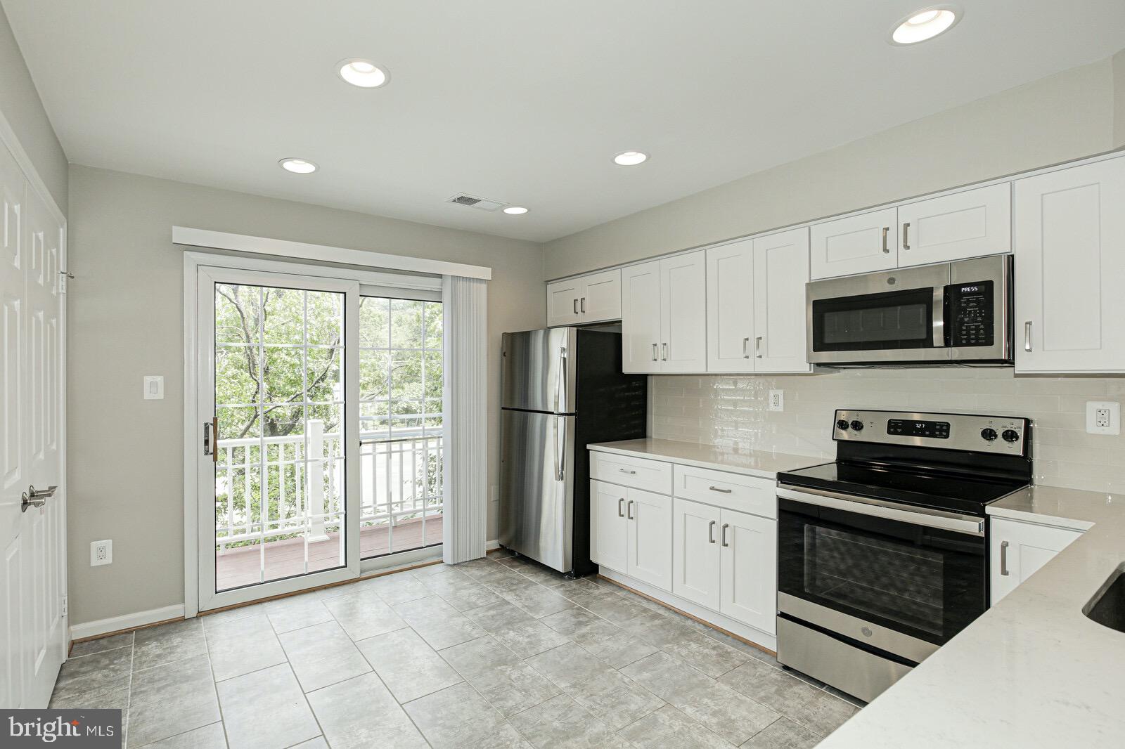 3002 South Glebe Road Arlington, VA 22206 - Photo 8 of 31 a kitchen with stainless steel appliances a stove sink microwave refrigerator and cabinets