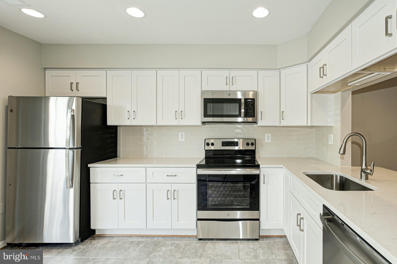 3002 South Glebe Road Arlington, VA 22206 - Photo 9 of 31 a kitchen with white cabinets and stainless steel appliances
