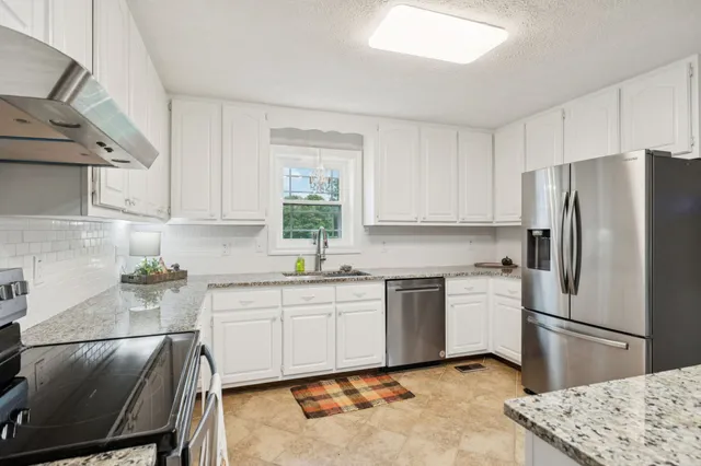 a view of kitchen with sink and refrigerator