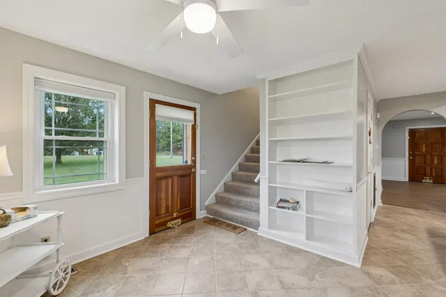 a view of a livingroom with a ceiling fan and window