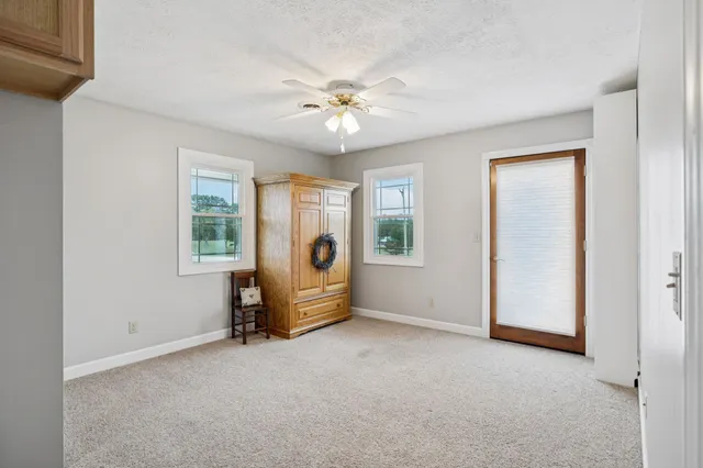 a front view of a house with a big yard and potted plants