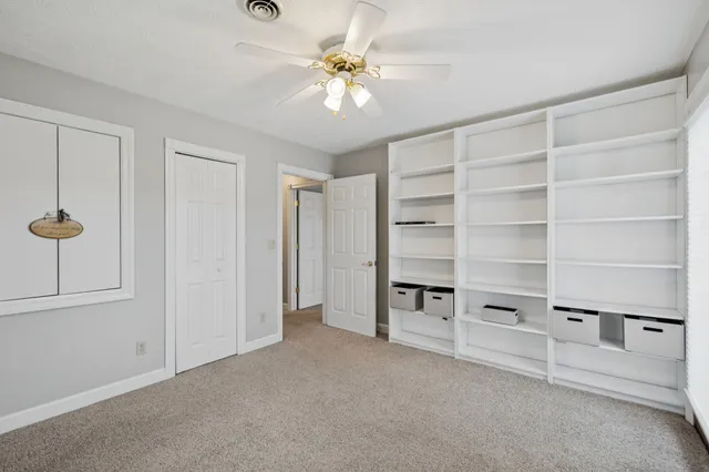 a front view of a house with a garden and lake view