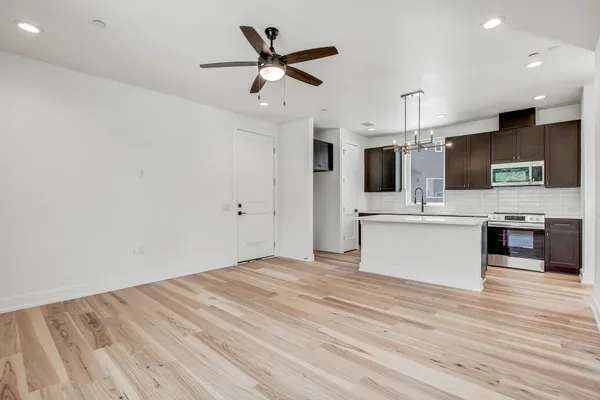 a view of kitchen with microwave oven stove and white cabinets