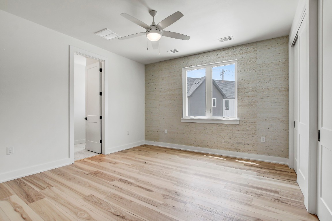 4127 East 12th Street, Unit 4 Austin, TX 78721 - Photo 13 of 32 Empty room with baseboards, light wood-style floors, and ceiling fan