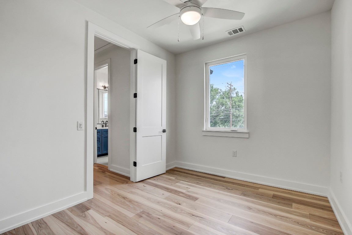 4127 East 12th Street, Unit 4 Austin, TX 78721 - Photo 19 of 32 Unfurnished room with ceiling fan, light wood-style floors, and baseboards