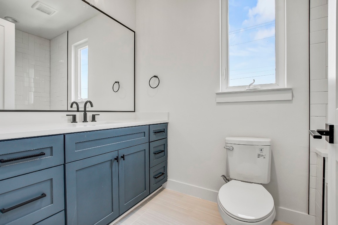 4127 East 12th Street, Unit 4 Austin, TX 78721 - Photo 20 of 32 Bathroom featuring baseboards, healthy amount of natural light, vanity, and toilet