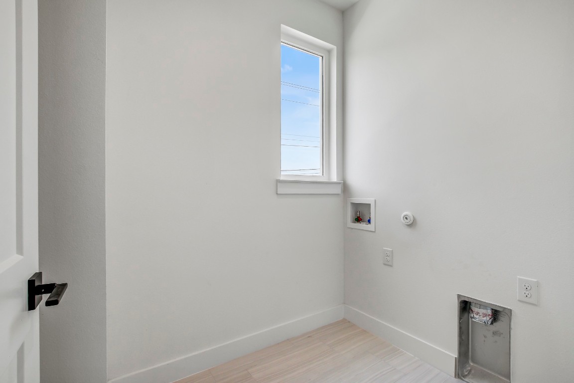 4127 East 12th Street, Unit 4 Austin, TX 78721 - Photo 22 of 32 Laundry area with hookup for a washing machine, hookup for a gas dryer, baseboards, light wood finished floors, and electric dryer hookup