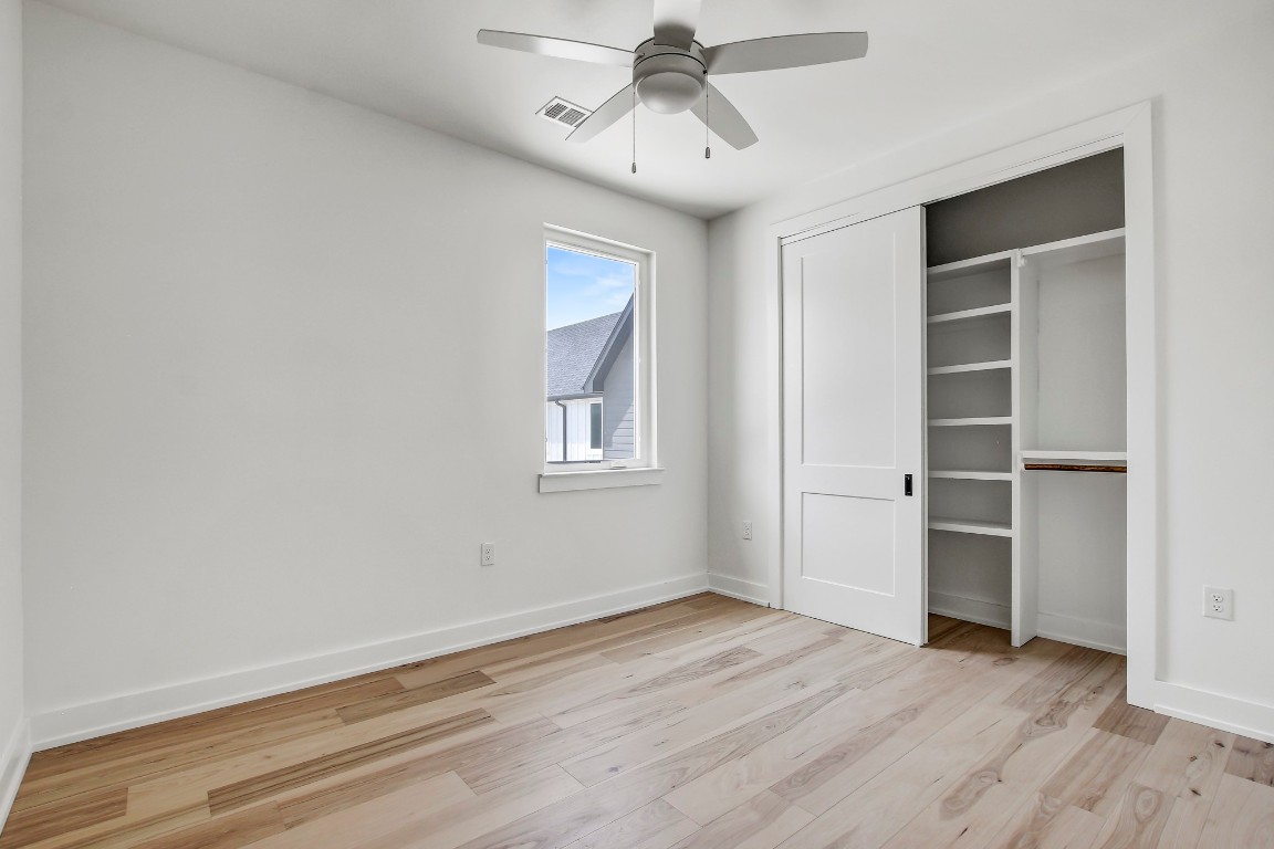 4127 East 12th Street, Unit 4 Austin, TX 78721 - Photo 24 of 32 Unfurnished bedroom with light wood-type flooring, baseboards, a closet, and ceiling fan