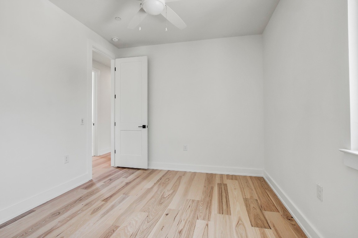 4127 East 12th Street, Unit 4 Austin, TX 78721 - Photo 25 of 32 Unfurnished room featuring a ceiling fan, wood finished floors, baseboards, and a smoke detector