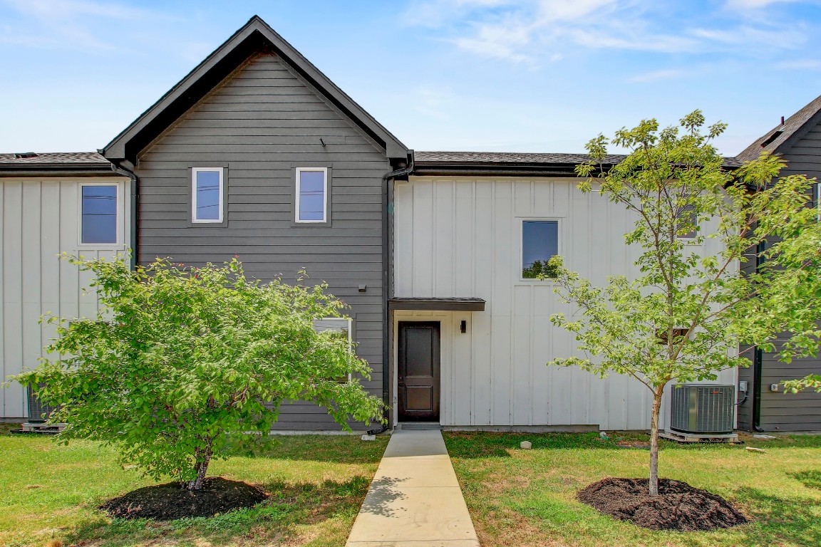 4127 East 12th Street, Unit 4 Austin, TX 78721 - Photo 30 of 32 View of front of property featuring board and batten siding, central AC, and a front lawn