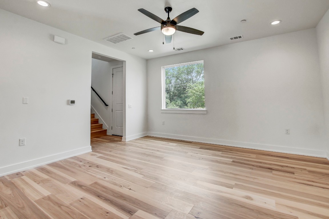 4127 East 12th Street, Unit 4 Austin, TX 78721 - Photo 3 of 32 Spare room with a ceiling fan, light wood-style flooring, recessed lighting, stairway, and baseboards