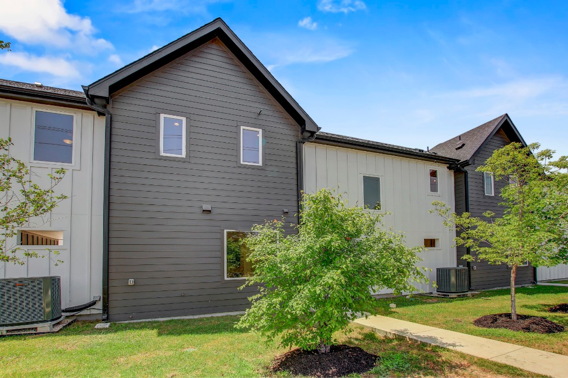 4127 East 12th Street, Unit 4 Austin, TX 78721 - Photo 31 of 32 View of property exterior with central AC unit and a lawn