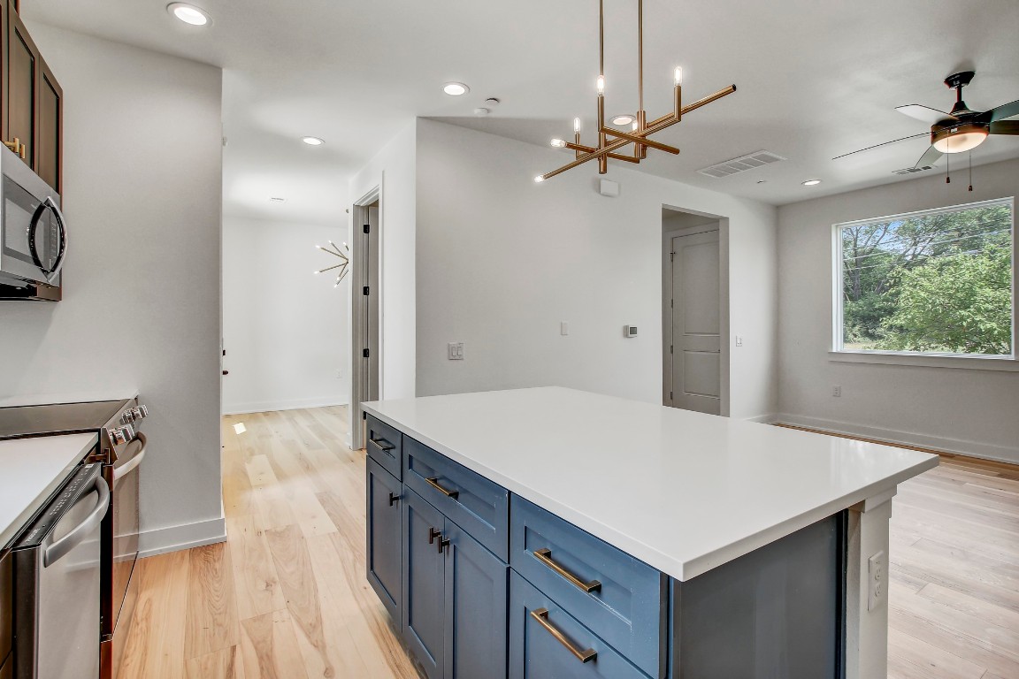 4127 East 12th Street, Unit 4 Austin, TX 78721 - Photo 8 of 32 Kitchen with stainless steel range, light wood-type flooring, a center island, light countertops, and recessed lighting
