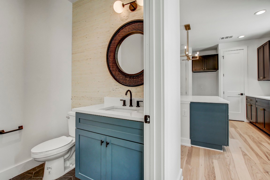4127 East 12th Street, Unit 4 Austin, TX 78721 - Photo 10 of 32 Bathroom featuring vanity, toilet, recessed lighting, a chandelier, and wood finished floors