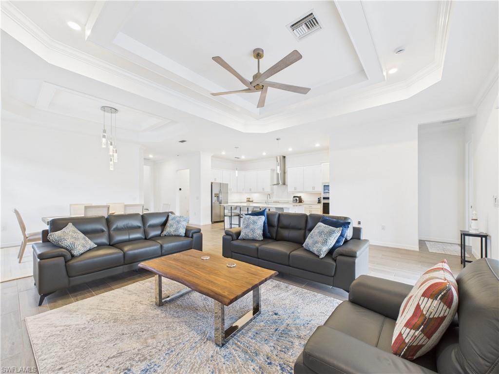 5412 Fancourt Links Way Ave Maria, FL 34142 - Photo 12 of 39 Living area featuring a raised ceiling, crown molding, ceiling fan, light wood finished floors, and recessed lighting