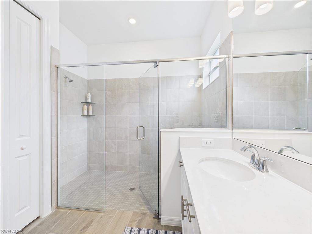 5412 Fancourt Links Way Ave Maria, FL 34142 - Photo 19 of 39 Bathroom featuring vanity, a stall shower, wood tiled floors, and recessed lighting